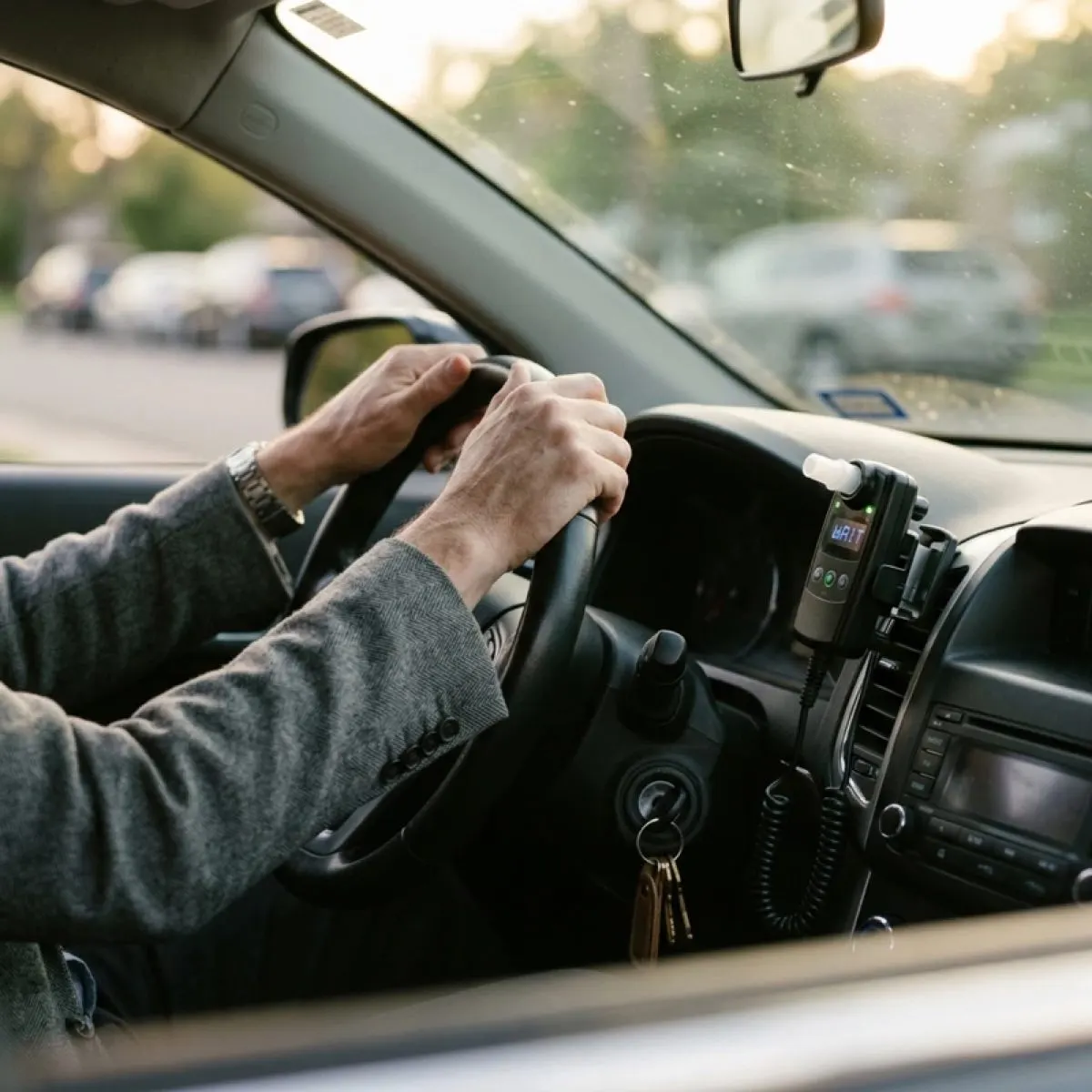 Ignition interlock handset mounted on a car dashboard beside the steering wheel