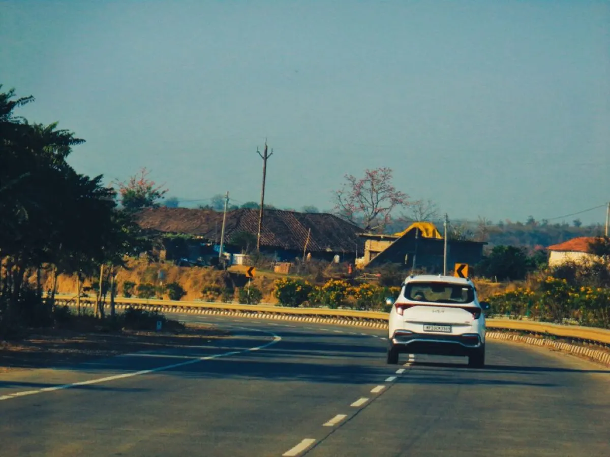 White car driving on a two-lane highway.