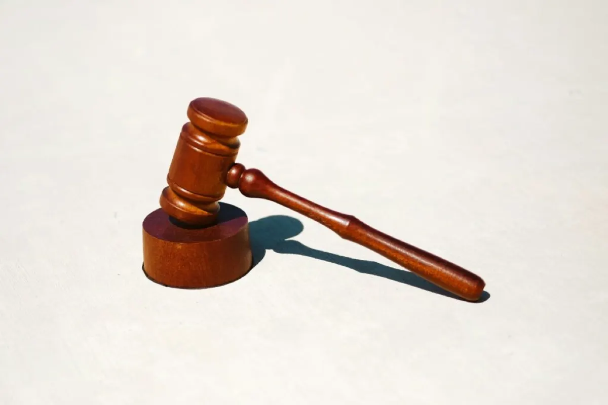 Wooden gavel resting on a light surface in a courtroom setting.